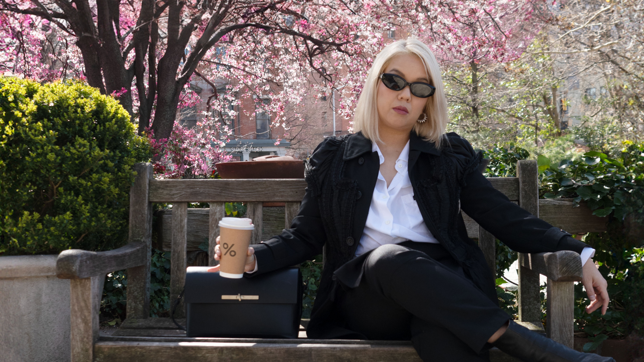 Diana Tsui with a cup coffee and a black LŪRA Yve bag